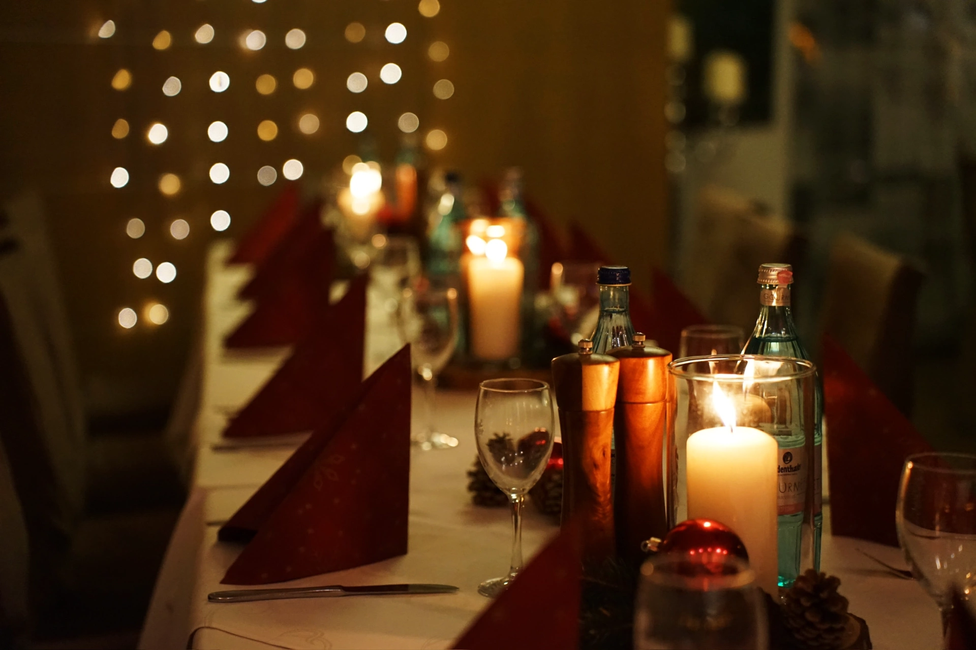 Weihnachtlich gedeckte Tafel im Ritter mit Kerzen, roten Servietten und warmem Licht